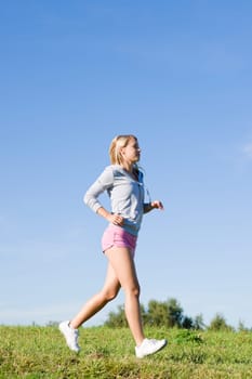 Sportive jogging young happy woman meadows blue summer sky