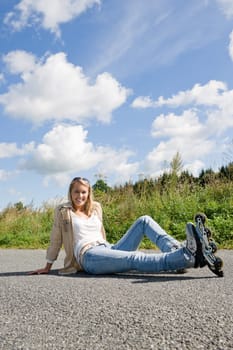 Inline skates young attractive woman wearing jeans sitting asphalt road