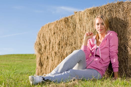 Sportive young woman relax lean against hay bales sunset countryside