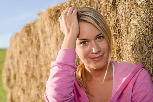 Sportive young woman relax lean against hay bales sunset countryside