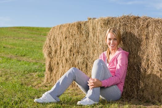 Sportive young woman relax lean against hay bales sunset countryside