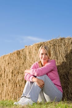 Sportive young woman relax lean against hay bales sunset countryside