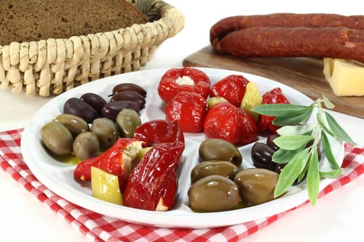 Olives and stuffed pepperoni on a white plate