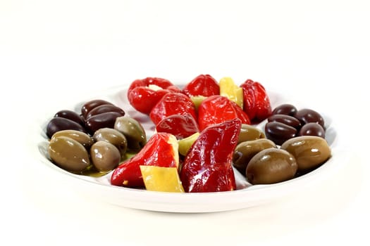 Olives and stuffed pepperoni on a white plate
