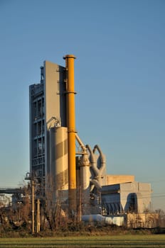 foreshortening of cement industrial plant, shot in in winter windy and sunny weather in plains of lombardy near bergamo