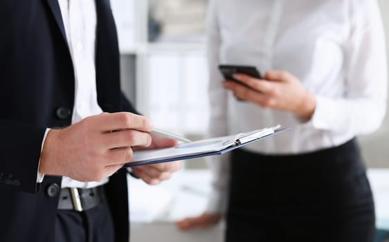 Male arm in suit hold silver pen and pad making note in office closeup. Deal consult delivery signature financial inspector job fill survey form discuss strategy project negotiation concept