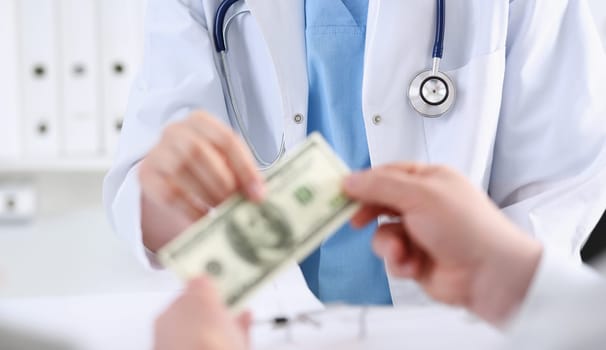 Female doctor hold in hands bunch of hundred dollars banknotes take or give them. Prestige and high paid job encash treatment illegal drug fraud anonymous visitor private visit reform concept