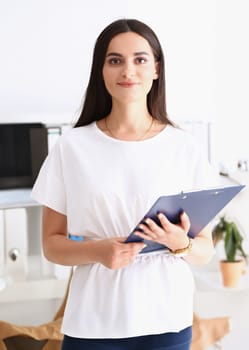 Indian woman worker portrait holding clipboard in hand smiling and looking at camera