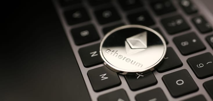 Coin crypto currency ethereum lies on the keyboard background theme of the gold exchange. Pyramid for money due to the rise or fall of the exchange rate.