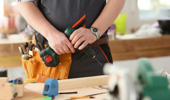 Arms of worker using electric drill closeup. Manual job DIY inspiration improvement job fix shop yellow helmet joinery startup idea industrial education profession career concept