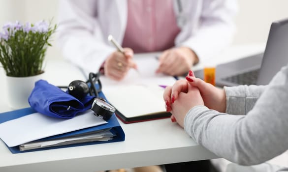 Female doctor hand hold silver pen filling patient history list at clipboard pad. Physical exam er disease prevention ward round visit check 911 prescribe remedy healthy lifestyle concept