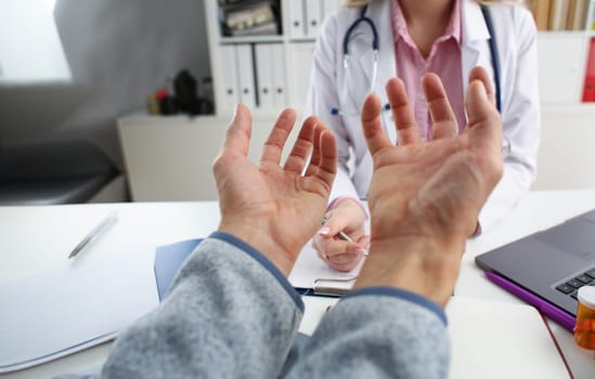 The man listened to the diagnosis in the doctor office, spread his hands and says why
