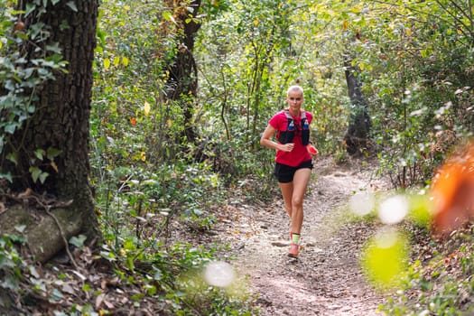 woman practicing trail running in the forest, concept of sport in nature and healthy lifestyle, copy space for text