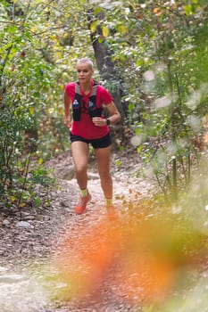 woman practicing trail running in the woods, concept of sport in nature and healthy lifestyle, copy space for text