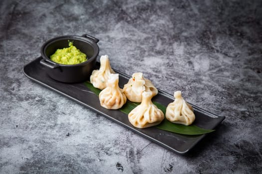 juicy khinkali with sauce on the black background