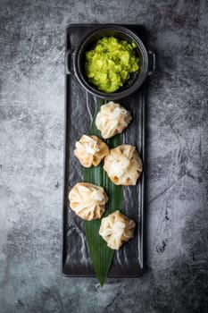 juicy khinkali with sauce on the black background