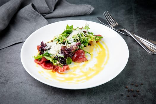 salad with red cabbage, meat, cheese and herbs with sauce