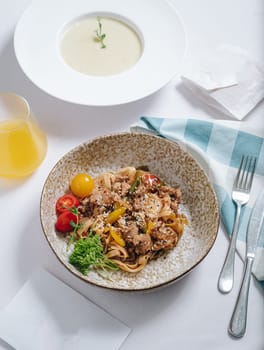 udon noodles with duck meat, herbs, sesame seeds and cherry tomatoes