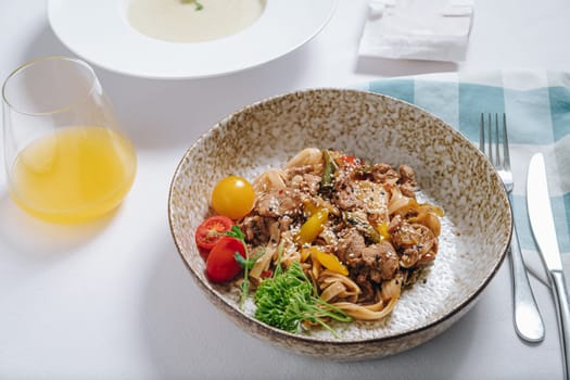 udon noodles with duck meat, herbs, sesame seeds and cherry tomatoes