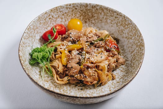 udon noodles with duck meat, herbs, sesame seeds and cherry tomatoes