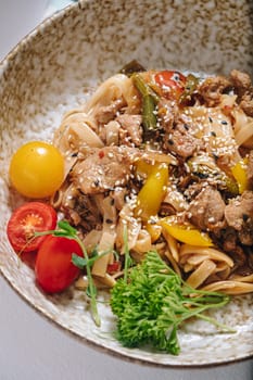 udon noodles with duck meat, herbs, sesame seeds and cherry tomatoes