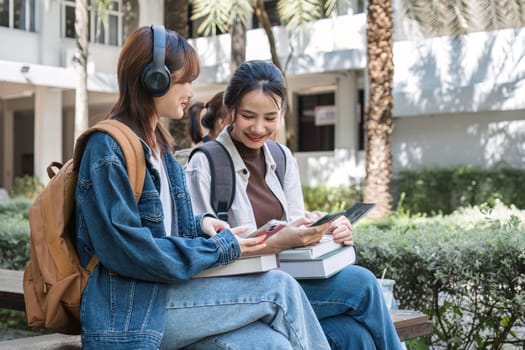 Group of cheerful Asian college students or friends laughing together while sitting in university..