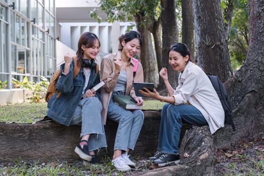 Group of cheerful Asian college students or friends laughing together while sitting in university..