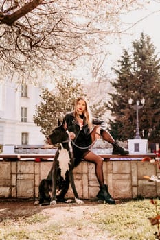 A woman walks with her Great Dane in an urban setting, enjoying the outdoors and the company of her dog