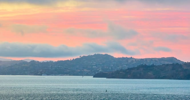 Image of Inspirational aerial of San Francisco Bay with pink salmon sky with hint of yellow gold over land