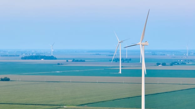 Image of Aerial wind farm standing in farmland with green and light green crops