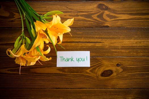 bouquet of beautiful yellow lilies on a dark wooden table