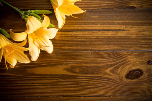 bouquet of beautiful yellow lilies on a dark wooden table