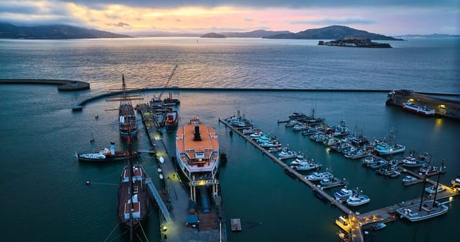 Image of Gorgeous sunset lighting over San Francisco Bay with Alcatraz and Hyde St Pier aerial