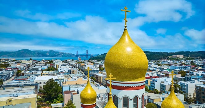 Image of Aerial roof of Russian orthodox Holy Virgin Cathedral with Golden Gate Bridge in distance