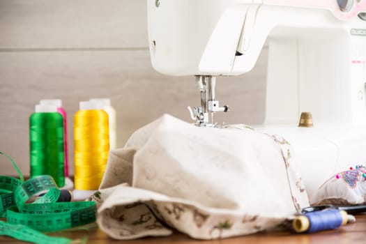 Sewing machine with fabric and threads for sewing, close-up. The working process. Part of a sewing machine with fabric.