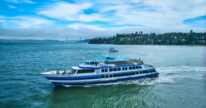 Image of Golden Gate Ferry with smaller boat near Tiburon and Golden Gate Bridge in distance aerial