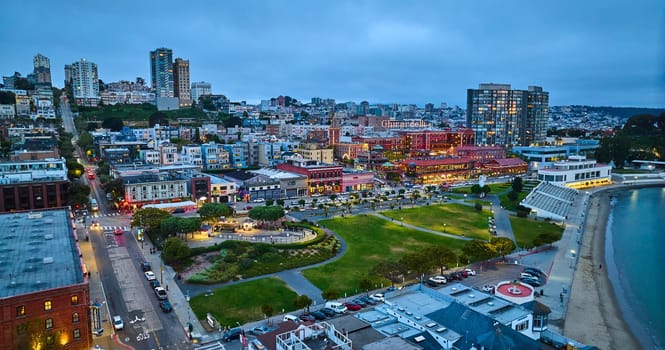 Image of Aerial over San Francisco Bay looking at Ghirardelli area with green park and city lit up at night