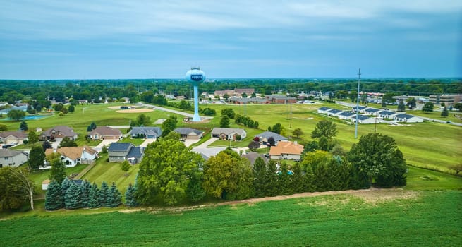 Image of Green fields in rural area aerial with Auburn water tower behind houses in small neighborhood