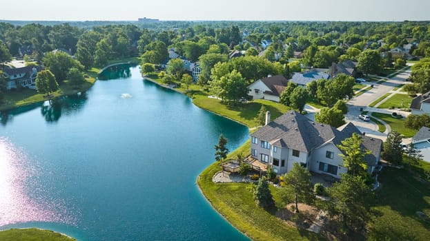 Image of Large rich houses next to manmade pond with water fountain aerial