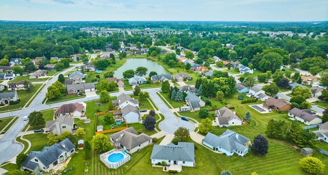 Image of Neighborhood with variety of homes and houses with fences and pool and variety of trees aerial