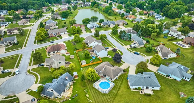 Image of Aerial over neighborhood with variety of homes and houses with fences and pools and trees