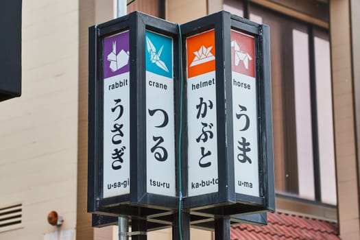 Image of Colorful sign with English and Japanese names for the rabbit and crane with horse and helmet
