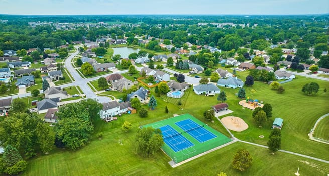 Image of Aerial suburban neighborhood with tennis court and playground