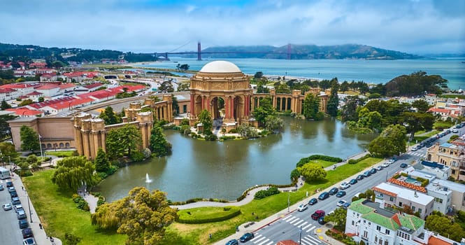 Image of Aerial full view Palace of Fine Arts lagoon and colonnade pillars with Golden Gate Bridge
