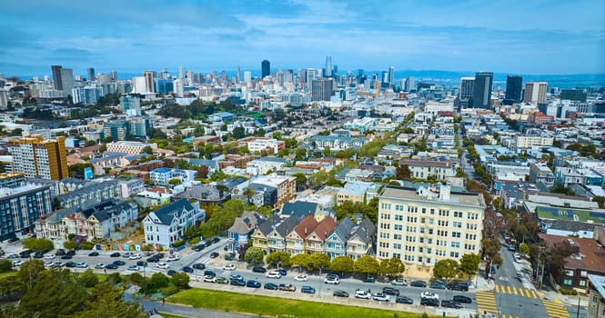 Image of Aerial The Painted Ladies with wide view of San Francisco city skyscrapers under pretty blue sky