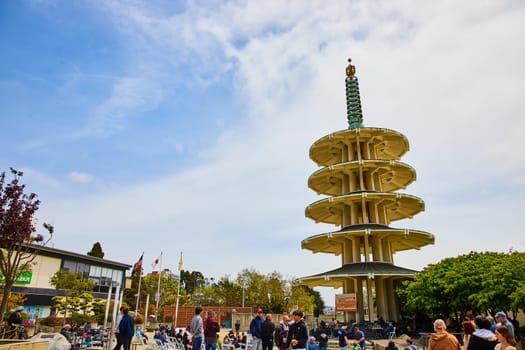 Image of Crowd of people standing and sitting around musicians at base of Peace Pagoda in Japantown