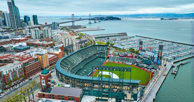 Image of Aerial Oracle Park Mission Bay side with Oakland Bay Bridge and downtown skyscrapers