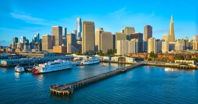 Image of Aerial Pier 7 at sunrise with San Francisco skyscraper skyline and boats docked in bay