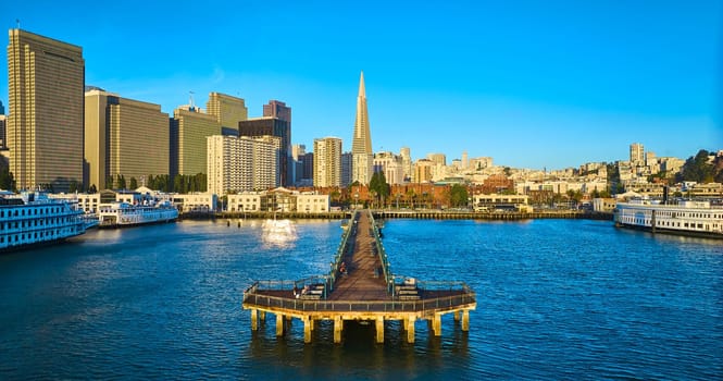 Image of Aerial full Pier 7 with Transamerica Pyramid glowing golden at sunrise and wide view of city