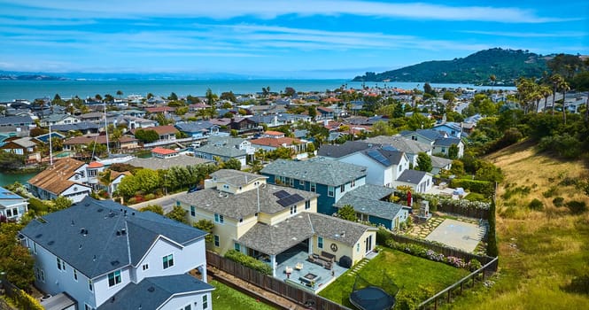 Image of Low aerial over rich houses in Tiburon overlooking houses in Paradise Cay Yacht Harbor